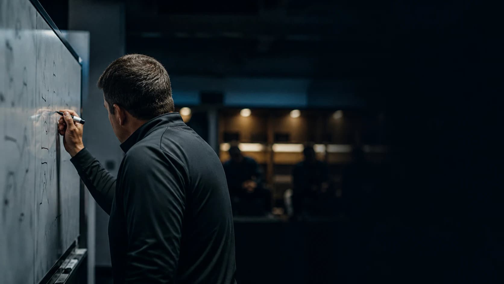 An anonymous coach revising the plan in a quiet locker room at halftime