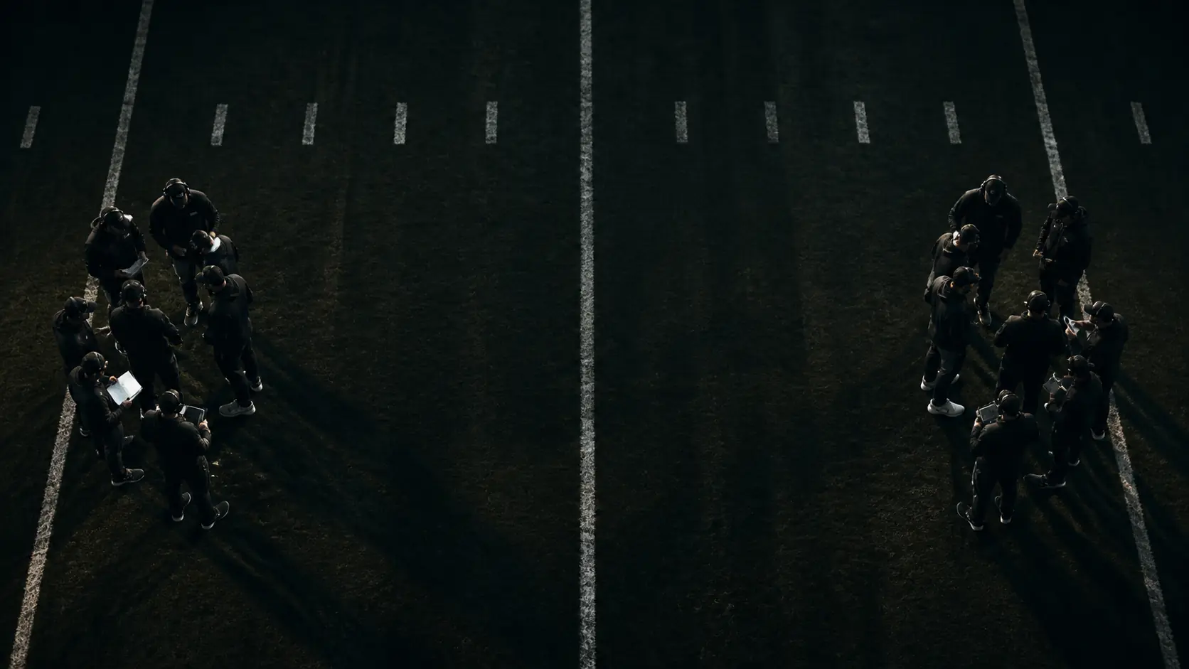 Two anonymous football coaching groups facing across a midfield seam from above